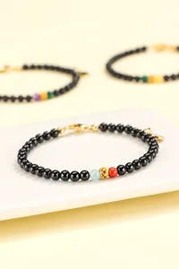 Detailed view of black agate beaded bracelet with red rhodochrosite and gold spacer