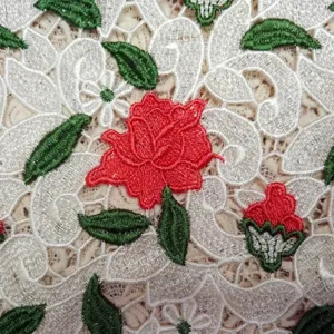 Macro view of premium water-soluble lace fabric with 3D red rose floral embroidery