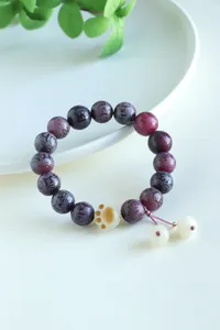 Close-up of purple mantra beads and cat paw pendant on bodhi bracelet