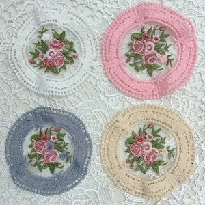 Detalle de posavasos circulares de encaje bordados con flores en cuatro colores