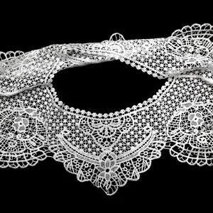Detailed close-up of white intricate hollow lace embroidery on a vintage style collar