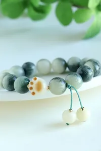 Close-up detail of charcoal-burned Bodhi seed bracelet with a cute cat paw shaped bead