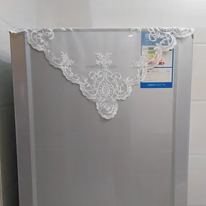 Close-up of white lace embroidered cover with hollow out details on home appliance