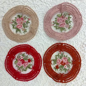 Vista detallada de cuatro posavasos circulares de encaje con bordado floral fino