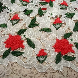 Detail view of water-soluble lace fabric with 3D red rose embroidery and hollow texture.