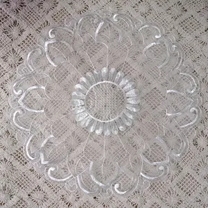 Close-up detail of white organza embroidered lace placemat with elegant floral pattern