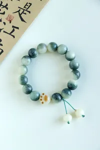 Detailed view of Mantra bodhi bead bracelet featuring a cute ceramic cat paw charm