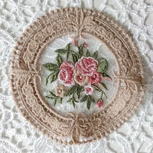 Primer plano de posavasos redondo de encaje vintage con bordado floral detallado