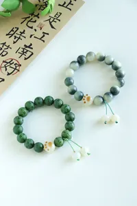 Detailed view of Bodhi bead bracelets with cat paw accent and Six-Word Mantra carving