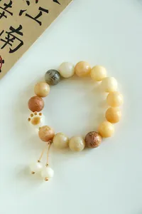 Detailed macro view of natural Bodhi seed bracelet with a cute carved cat paw charm
