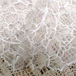 Close-up detail of delicate white embroidered lace organza placemat texture and pattern