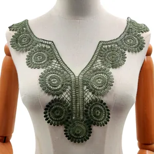 Detail of dark green water-soluble lace collar applique on a white mannequin.
