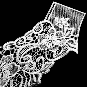 Macro view of intricate white water-soluble lace floral embroidery for elegant clothing collar
