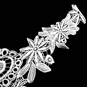 Close-up detail of white water-soluble milk silk lace embroidery with hollow floral patterns
