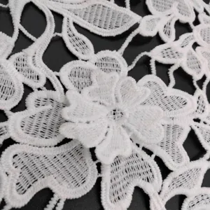 Detailed view of white water-soluble lace fabric with 3D milk silk floral embroidery