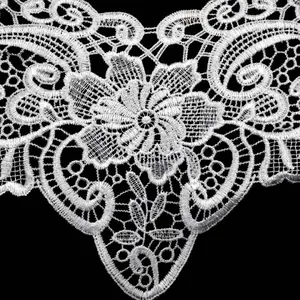 Close-up view of intricate white water-soluble lace floral embroidery detail for clothing