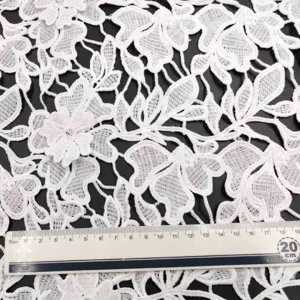 Close-up of white water-soluble lace fabric with 3D milk silk floral embroidery.