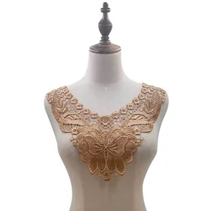 Detailed view of golden water-soluble butterfly lace collar applique on dress form