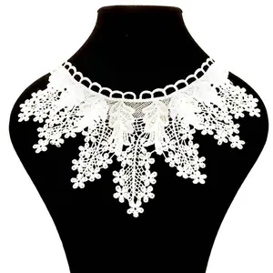 Close-up of white water-soluble lace collar with detailed flower embroidery.
