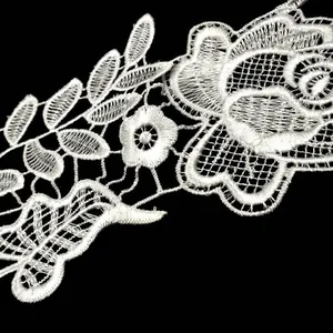 Close-up of white water-soluble lace embroidery with intricate floral and leaf patterns.