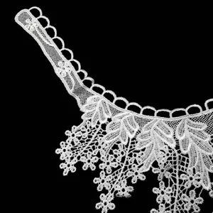 Detailed macro shot of white water-soluble lace collar with delicate floral embroidery patterns