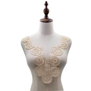 Detailed view of beige water-soluble embroidered lace collar applique on a mannequin torso