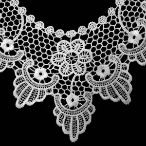Detalle macro de cuello de encaje blanco soluble con bordado floral hueco en relieve 3D.