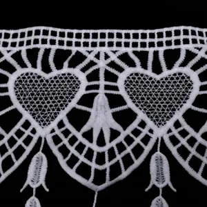 Macro detail showing heart-shaped hollow embroidery on white milk silk lace trim