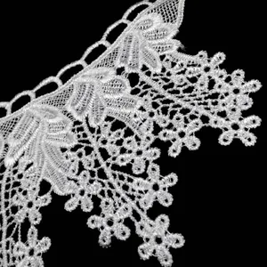 Close-up of white water-soluble lace collar with delicate floral embroidery details.