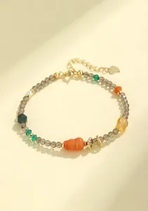 Vista detallada de pulsera de cuarzo ahumado facetado con dije de calabaza dorada