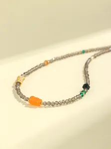 Vista macro detallada de cuentas de cuarzo ahumado facetado de 3mm con jade naranja