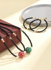 Detail view of black agate necklaces with handcrafted lacquer beads and gemstones.