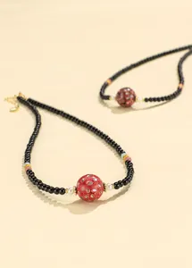 Detailed shot of black agate beaded necklace with red lacquer bead and shell inlay