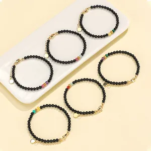 Handmade black agate beaded bracelets with colorful gemstone accents and gold-plated clasps.