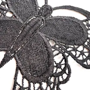 Close-up of intricate black butterfly embroidered lace patch showing fine thread texture