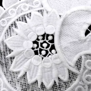 Macro detail of white water-soluble milk silk lace with 3D applique flower embroidery