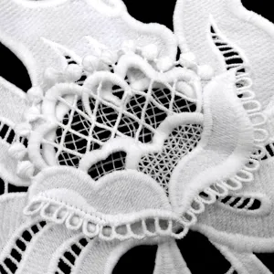 Close-up detail of white water-soluble milk silk lace with 3D double-layer applique flower