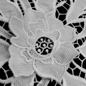 Macro detail of 3D double-layer applique flower on white water-soluble milk silk lace fabric
