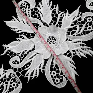 Close-up of 3D white milk silk embroidered lace floral trim with measurement scale
