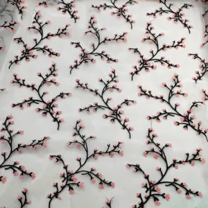 Detail of delicate pink cherry blossom floral embroidery on white organza mesh textile