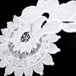 Close-up detail of white water-soluble milk silk lace featuring heavy floral embroidery