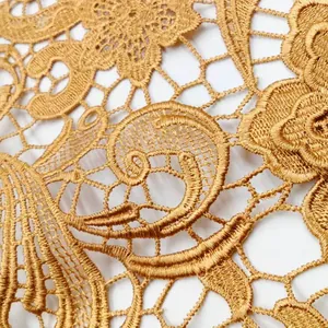 Gros plan détaillé de tissu en dentelle soluble à l'eau dorée avec motifs paisley brodés