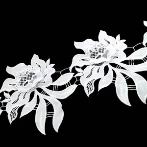 Detailed macro view of white water-soluble milk silk embroidery lace trim with 3D floral design