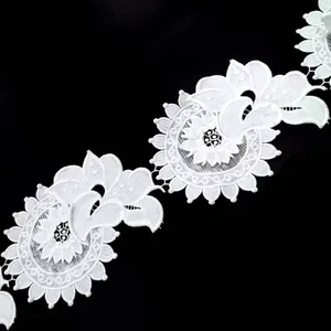 Macro detail of white milk silk water soluble lace trim with 3D floral embroidery