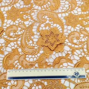 Vue détaillée du tissu en dentelle soluble dans l'eau doré avec broderie florale et paisley