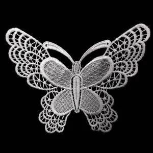 Detailed macro view of white embroidered butterfly lace patch for clothing decoration.