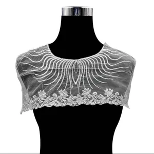 Detailed view of white water-soluble lace embroidered fake collar on black mannequin