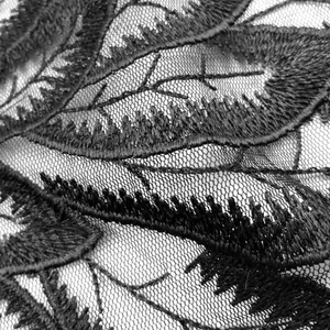 Makroaufnahme von schwarzer wasserlöslicher Spitze mit floralen Stickerei-Details