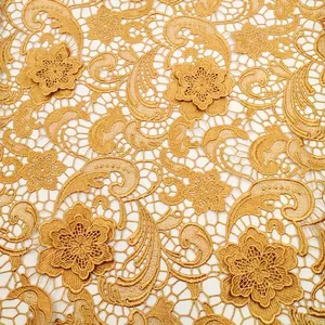 Gros plan détaillé sur un tissu en dentelle soluble dorée avec broderie de cachemire