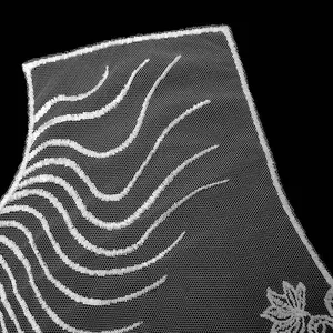 Detailed macro view of white embroidered mesh lace collar with elegant wavy line patterns